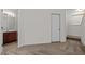 Neutral carpeted hallway featuring bathroom and door for additional space at 100 Stratford Lakes Dr # 270, Durham, NC 27713