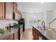 Well-equipped kitchen with wood cabinets, modern appliances, and natural light from the window at 100 Stratford Lakes Dr # 270, Durham, NC 27713
