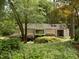 Landscaped home exterior with mature trees and bushes, offering a secluded and natural setting at 101 Solway Ct, Cary, NC 27511