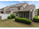 A manicured backyard featuring a screened porch and mature landscaping at 1020 Kingston Grove Dr, Cary, NC 27519