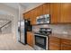 Open kitchen with stainless steel appliances and wood cabinets at 1020 Kingston Grove Dr, Cary, NC 27519