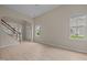 Open-concept living room featuring wood-look floors, windows, and staircase access at 1020 Kingston Grove Dr, Cary, NC 27519