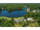 Breathtaking aerial view of a waterfront property nestled amongst lush trees, showcasing the serene lake at 103 Lakeway Ct, Cary, NC 27511