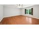 Light-filled bedroom with beautiful wood floors, a ceiling fan, and a large window offering a serene view at 103 Lakeway Ct, Cary, NC 27511