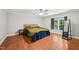 This bedroom offers hardwood floors, a large window with curtains, and a bed with colorful pillows at 103 Lakeway Ct, Cary, NC 27511