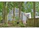Exterior view of home with muted gray siding and brick foundation, surrounded by mature trees and fenced yard at 103 Lakeway Ct, Cary, NC 27511
