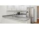 Updated kitchen features granite counters, a stainless steel refrigerator, and white cabinets at 103 Lakeway Ct, Cary, NC 27511