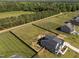 Aerial view of a gray home with a large backyard, garden area, and surrounding greenery at 105 Scotland Dr, Youngsville, NC 27596