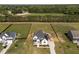 Aerial view of a modern white house with a well-kept yard and surrounding greenery at 105 Scotland Dr, Youngsville, NC 27596