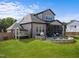 Backyard with a sunroom, outdoor kitchen, fire pit, manicured lawn, and surrounding greenery at 105 Scotland Dr, Youngsville, NC 27596