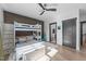 Bright bedroom featuring a bunk bed, ceiling fan, hardwood floors, and a view into the ensuite bathroom at 105 Scotland Dr, Youngsville, NC 27596