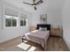 Bright bedroom featuring natural light, hardwood floors, large windows, and a cozy bed with decorative pillows at 105 Scotland Dr, Youngsville, NC 27596