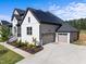 Two-story white brick home with a two-car garage, solar panels and manicured landscaping at 105 Scotland Dr, Youngsville, NC 27596