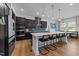 Modern kitchen features black cabinets, stainless steel appliances, a large island, and pendant lighting at 105 Scotland Dr, Youngsville, NC 27596