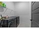 Contemporary laundry room with modern washer and dryer set and a metal storage rack at 105 Scotland Dr, Youngsville, NC 27596