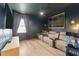 Inviting living room with dark walls, home theatre seating, and a window view with a periodic table art piece at 105 Scotland Dr, Youngsville, NC 27596