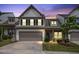 Two-story townhouse showcasing a manicured lawn, two car garage and exterior brick accent at 107 Explorer Dr, Morrisville, NC 27560