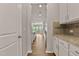 Hallway view of a gourmet kitchen, with white cabinets, granite countertops, and stainless steel appliances at 107 Explorer Dr, Morrisville, NC 27560