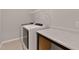 Functional laundry room with a white washer and dryer, a countertop, and storage shelves at 107 Explorer Dr, Morrisville, NC 27560