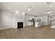 Open-concept living room with a fireplace and a view into the modern kitchen and island at 107 Explorer Dr, Morrisville, NC 27560