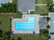 Aerial view of a community pool with lounge chairs and umbrellas surrounded by lush greenery and neighborhood buildings at 107 Explorer Dr, Morrisville, NC 27560