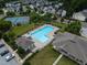 Aerial shot of community pool with tennis court, surrounded by trees and neighborhood homes at 107 Explorer Dr, Morrisville, NC 27560