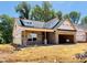 A brick exterior with an attached garage is under construction, set against a backdrop of green trees and blue sky at 1087 Fairhaven Dr # 48, Mebane, NC 27302