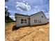 A view of the side and back of the house reveals large windows and newly installed vinyl siding at 1087 Fairhaven Dr # 48, Mebane, NC 27302