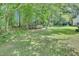 Large backyard with mature trees and a grassy area perfect for outdoor activities at 109 Grange Dr, Wendell, NC 27591