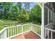 Relaxing back porch with wood decking, white railing and view of the expansive backyard at 112 Sterling Ridge Way, Cary, NC 27519
