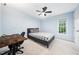 Light blue bedroom featuring a wood desk, ceiling fan and neutral carpet at 112 Sterling Ridge Way, Cary, NC 27519