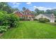 Gorgeous brick home with a lush green lawn, mature trees, and well-maintained landscaping at 112 Sterling Ridge Way, Cary, NC 27519