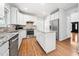 Kitchen with stainless steel appliances, granite countertops, white cabinets and hardwood floors at 112 Sterling Ridge Way, Cary, NC 27519