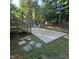 Backyard with a concrete patio, a wooden deck staircase, and a natural wooded backdrop at 119 Comanche Dr, Louisburg, NC 27549