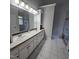 Bathroom features a double sink vanity, large mirrors and a glass enclosed shower at 119 Comanche Dr, Louisburg, NC 27549