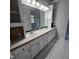 Bathroom features a double sink vanity, large mirrors and a glass enclosed shower at 119 Comanche Dr, Louisburg, NC 27549