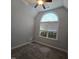 Neutral bedroom with a large arched window, ceiling fan and plush carpeting providing comfort at 119 Comanche Dr, Louisburg, NC 27549