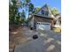 View of long concrete driveway leading up to the attached two-car garage of this brick house at 119 Comanche Dr, Louisburg, NC 27549