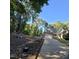 View of the front yard with driveway leading up to the brick home with mature trees surrounding the property at 119 Comanche Dr, Louisburg, NC 27549