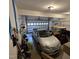 Well-lit garage with a parked car, golf cart, ample storage and an open garage door at 119 Comanche Dr, Louisburg, NC 27549