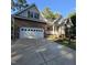 Brick and vinyl home with attached two-car garage and mature landscaping in front yard at 119 Comanche Dr, Louisburg, NC 27549