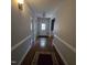 Entryway hallway with hardwood floors, white trim, and an exterior door leading to the outside at 119 Comanche Dr, Louisburg, NC 27549
