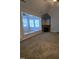 Carpeted living room features a fireplace and an adjacent room with large windows and ceiling fan at 119 Comanche Dr, Louisburg, NC 27549
