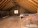 Large unfinished attic with exposed wood framing and a small window at 119 Long Shadow Ln, Cary, NC 27518