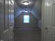 View of a spacious finished attic with neutral carpet, a window, and a ceiling fan at 12 Crail Ct, Durham, NC 27712