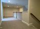 Spacious finished basement area with carpeted floors and a staircase to the upper level at 12 Crail Ct, Durham, NC 27712