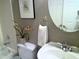 Bathroom features patterned tile accent wall and a round mirror over pedestal sink at 12 Crail Ct, Durham, NC 27712