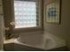 Bright bathroom featuring a soaking tub with stylish tile block window for natural light at 12 Crail Ct, Durham, NC 27712