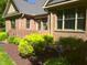 Charming brick home featuring a brick porch with shrubs and landscaping at 12 Crail Ct, Durham, NC 27712