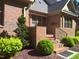 Brick front porch with a small evergreen tree, shrubbery and mulch at 12 Crail Ct, Durham, NC 27712